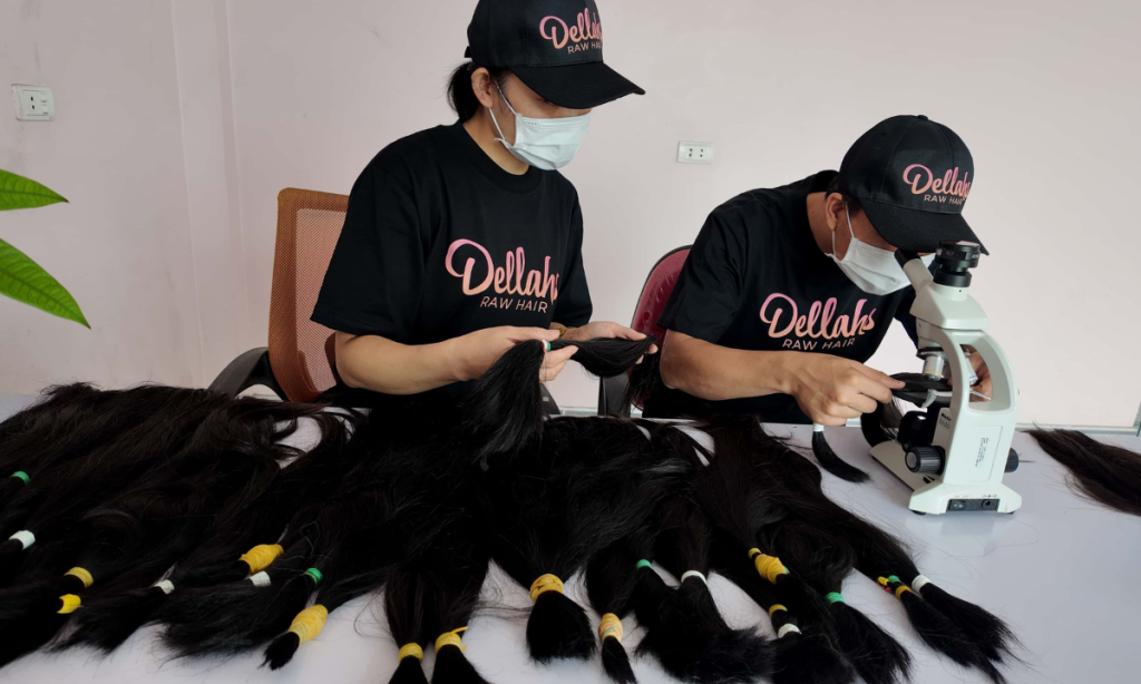 a cambodian hair factory called Dellahs hair doing hair quality control. they are looking at freshly cut donor hair through a microscope